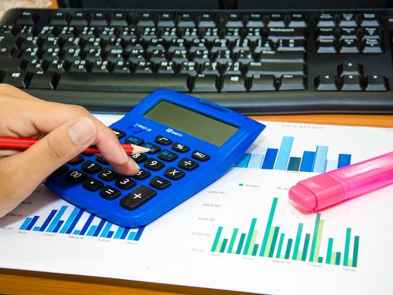 Análisis financiero con calculadora y gráficos sobre la mesa de un despacho